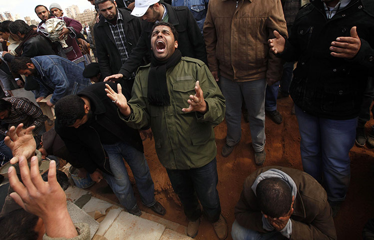 Libya chaos: A mourner reacts next to the grave of a rebel killed by loyalist forces