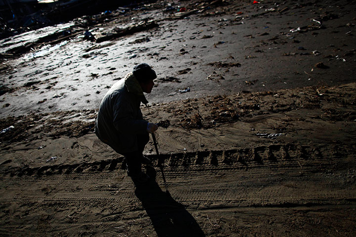 Japan survivors: An elderly man makes his way through the flooded area of Rikuzentakata