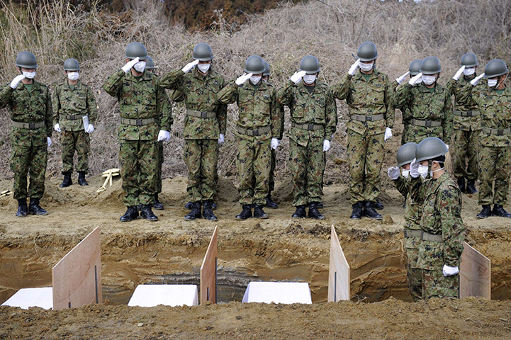 Japan survivors: Mass burial of tsunami victims at a cemetery in Onagawa