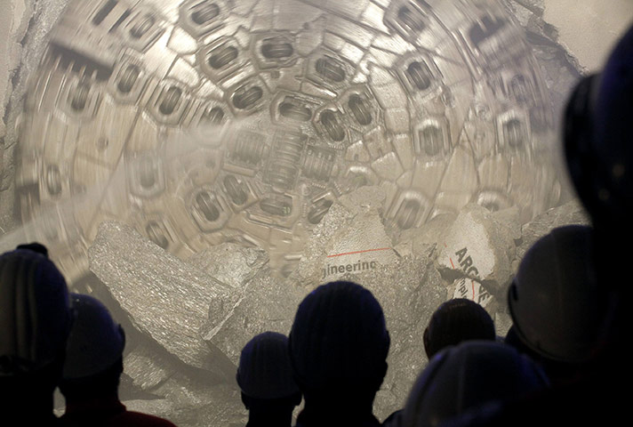 24 hours: Switzerland: Miners watch a giant drill machine at the Gotthard Base Tunnel