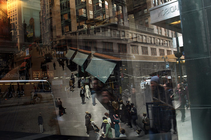 24 Hours: People reflected in a window showing a vintage picture of New York City