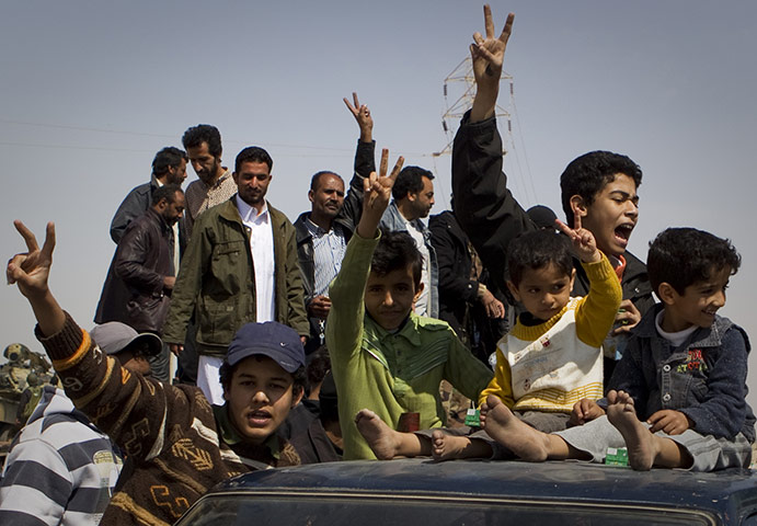 Ajdabiya seized by rebels: Libyan children celebrate on top of a car after rebels took the city