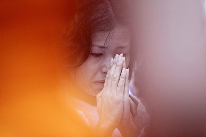 24 hours in pictures: Woman prays for victims of the earthquake and tsunami in Japan