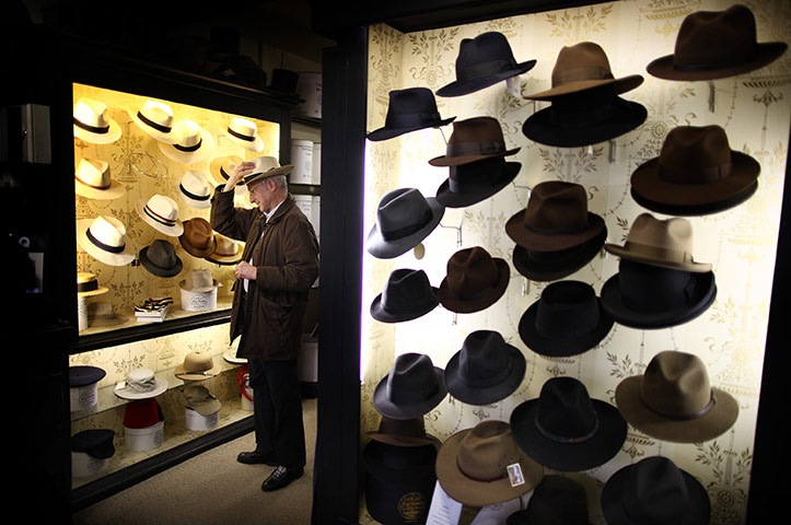 24 hours in pictures: A customer tries on a Panama hat at Lock & Co. Hatters, London
