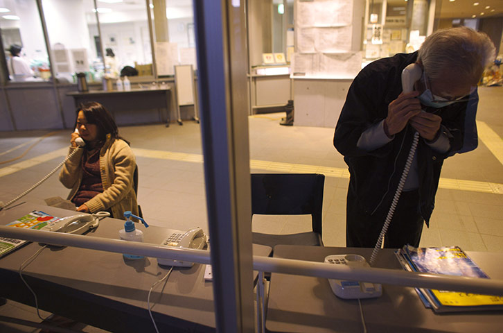 Japan aftermath: Earthquake victims make phone calls at evacuation centre in Kesennuma
