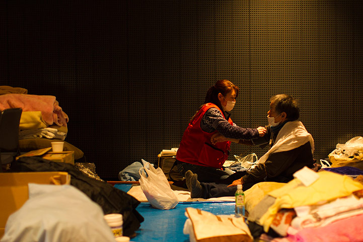 Japan aftermath: An earthquake victim receives treatment by medical personnel in Ofunato
