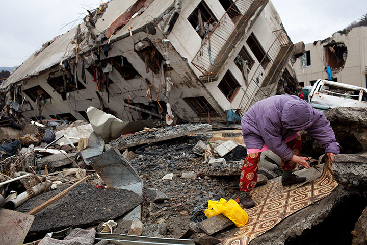 Japan aftermath: A resident salvages from a building destroyed by the tsunami in Onagawa