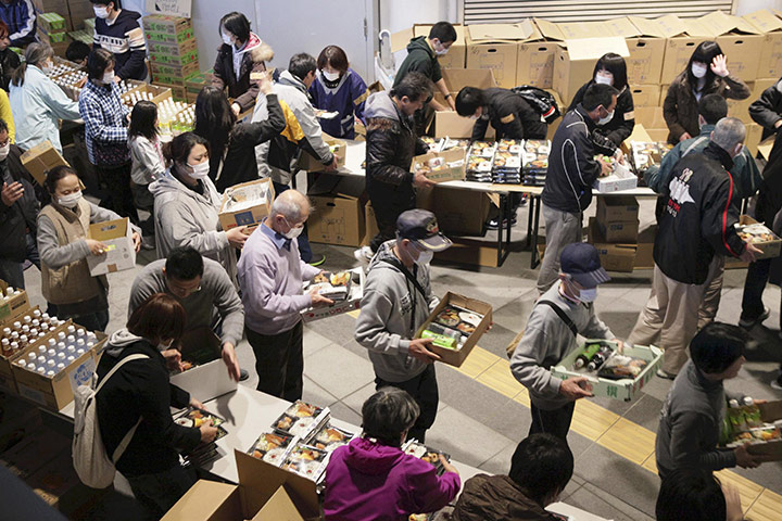 Japan aftermath: Evacuees from Fukushima eceive meals for dinner at an evacuation centre