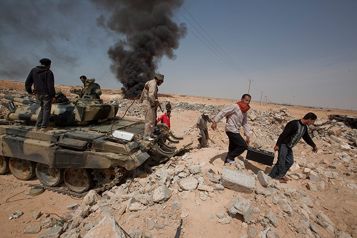 Sean Smith in Libya: Rebel supporters scavenge for scrap from a Gaddifi tank in Adjabaya  