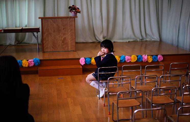  A pupil waits for the start of a graduation ceremony at Ashinome kindergarten Kesenuma, Japan