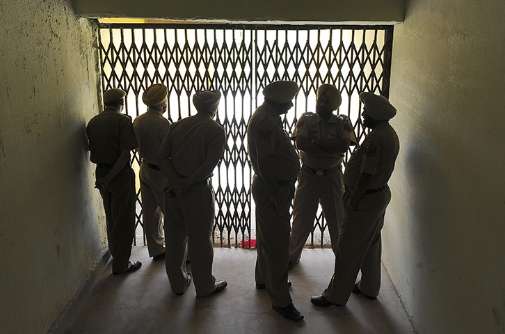 Mohali, India: Police officers watch the Pakistan cricket team during a training session