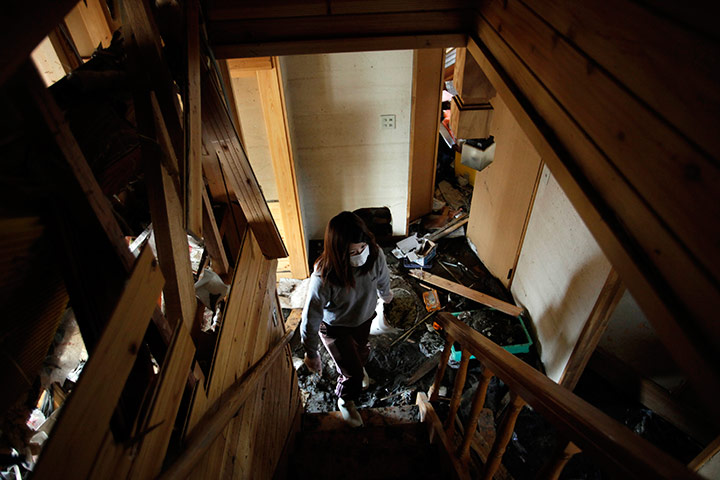 Japan: Woman cleans debris in her house in Kesennuma, Japan