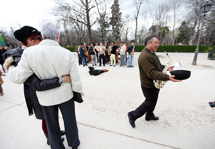 Graeme Robertson in Spain: A busker passes his hat around the crowd in Parque del Buen Retiro 