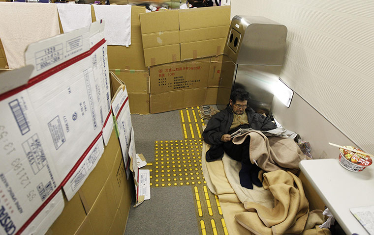 Japan nuclear crisis: An evacuee reads newspaper at an evacuation center in Koriayama