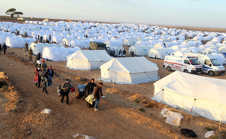 Refugees Flee Libya: Egyptians carry their belongings as they cross into Tunisia