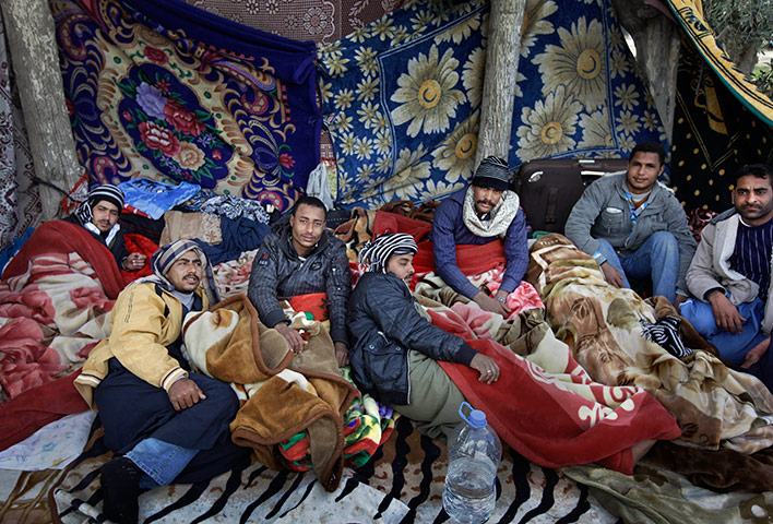 Refugees Flee Libya: Egyptian migrant workers lie under blankets in a makeshift open-air camp