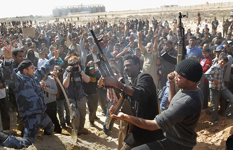 Libya Gallery: Rebel fighters shoot into the air during a funeral for comrades in Ajdabiya