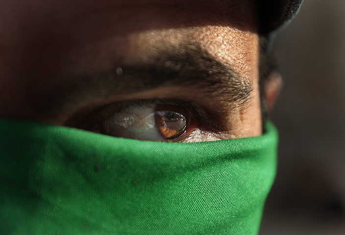 24 hours: A pro Gadaffi supporter wears a green over his face 