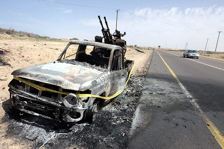 Libya unrest continues: A burned-out vehicle on the side of a road leading to Brega