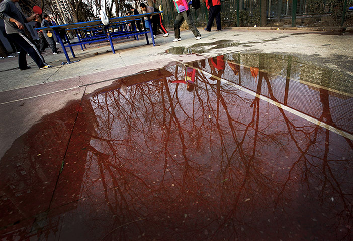 from the agencies: Sunday table tennis players are refelcted in a puddle in a public park 