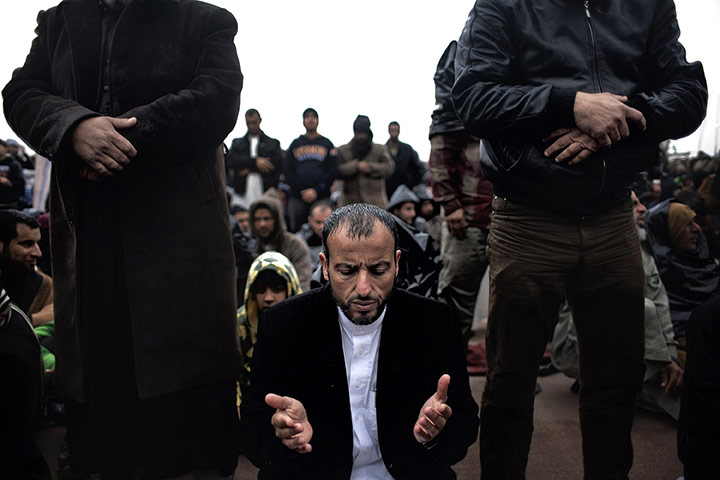 Libya protests: Libyans pray in pouring rain in Benghazi