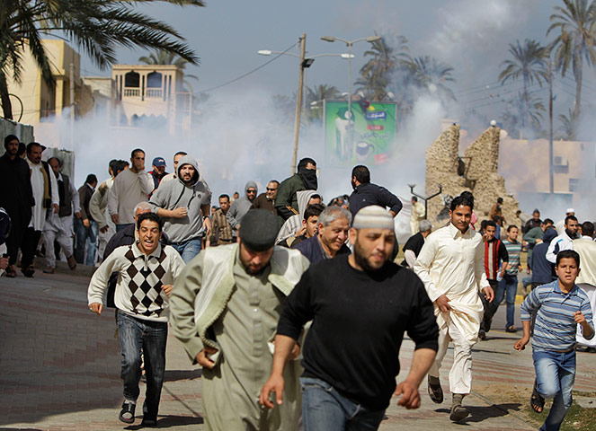 Libya protests: anti-Gaddafi protesters run from teargas
