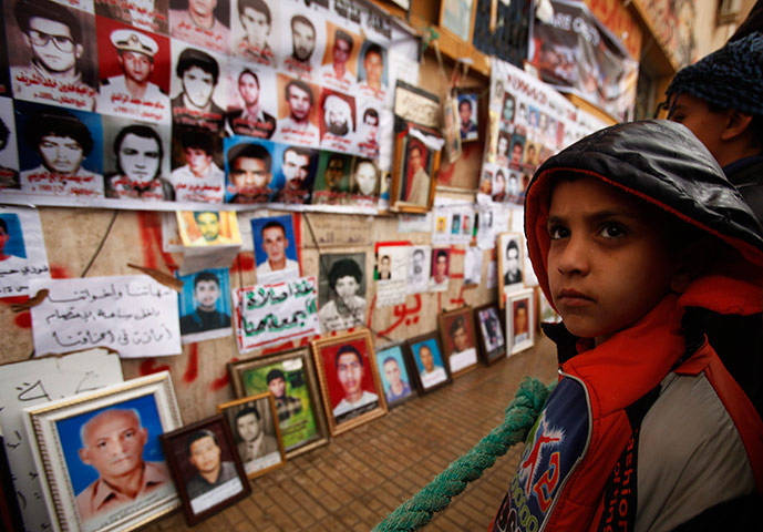 Libya protests: a boy looks at pictures of missing and killed Libyans in Benghazi