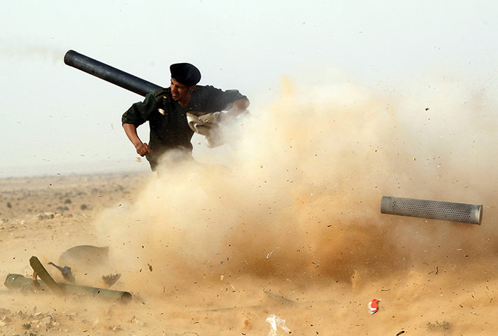 libya unrest continues: A rebel fighter fires a cannon during a battle near Ras Lanuf