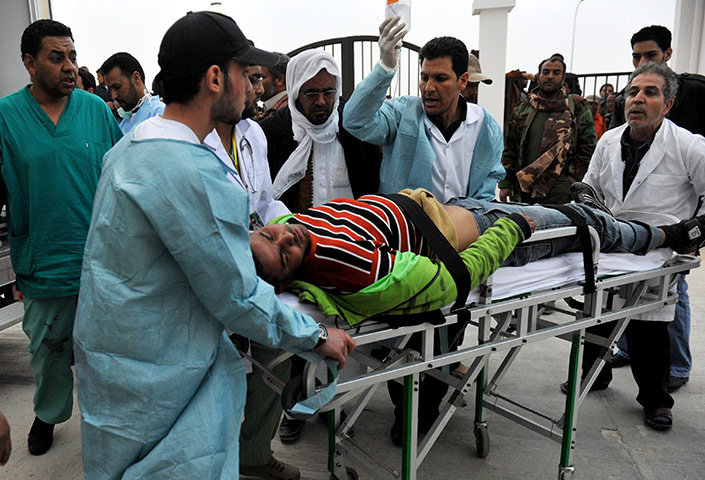 libya unrest continues: An injured Libyan rebel fighter is rushe