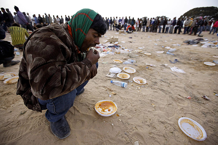 libya unrest continues: A Bangladeshi migrant eats 