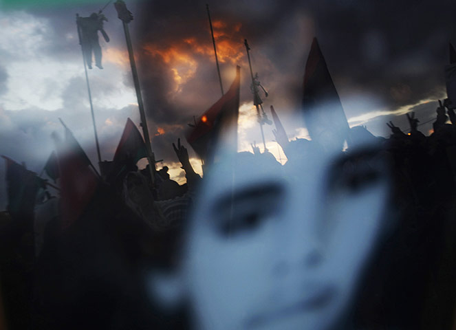 24 hours in pictures: Benghazi, Libya: Anti-Gaddafi protesters reflected in a photo of a youth