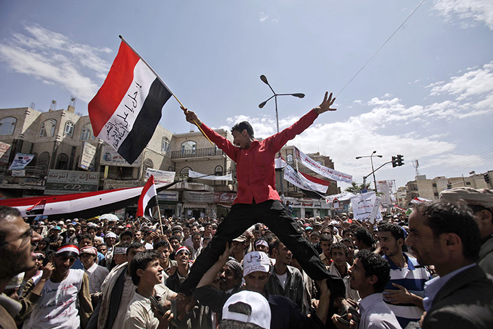 24 hours in pictures: Sana'a, Yemen: An anti-government protester hoisted above tthe crowd