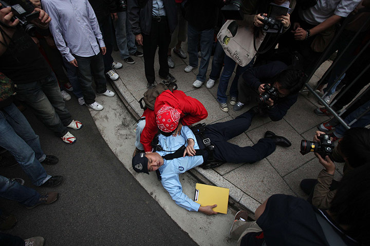24 hours in pictures: Hong Kong, China: A policeman lies on the ground following a scuffle