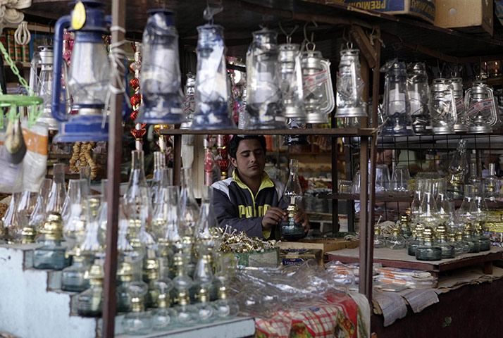 24 hours in pictures: Baghdad, Iraq: A shopkeeper with a display of oil lamps at a market