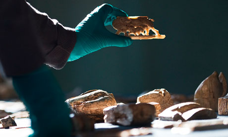 A technician holds a carved ivory motif