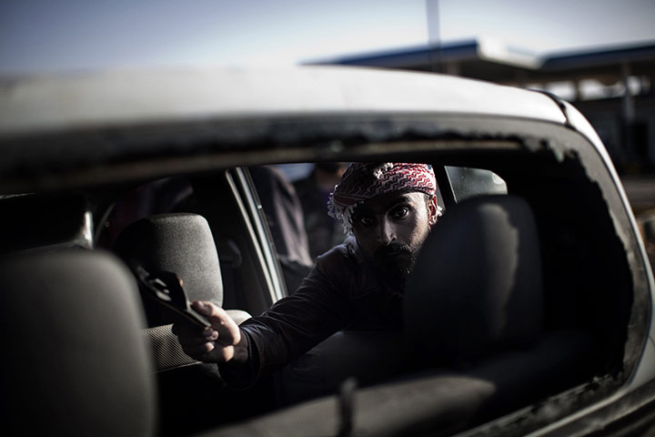 Libya battles continue: A Libyan man shows a baby slipper from the inside of a civilian car 
