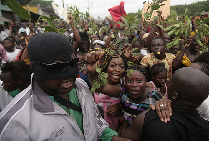 Ivory Coast violence: A man in a balaclava provides security at a rally of supporters of Ouattara