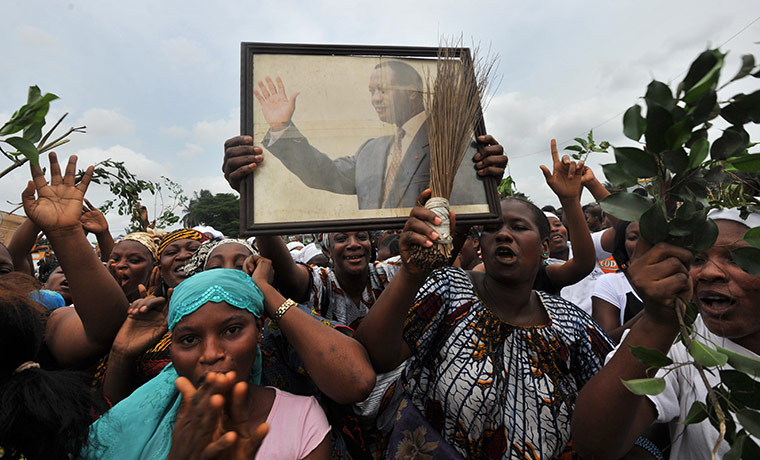 Ivory Coast violence: Women hold a portrait of presidential claimant  Alassane Ouattara