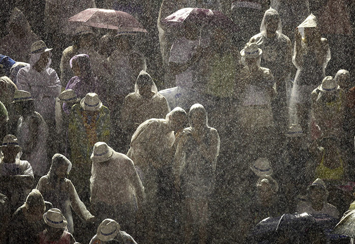 from the agencies : Spectators watch the Grande Rio samba school parade in the rain