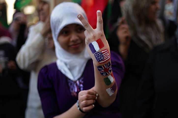 24 hours in pictures: A Libyan girl shows a victory gesture with her painted arm