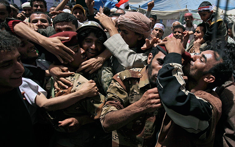 24 hours in pictures: Anti-government protestors embrace and kiss Yemeni army officers