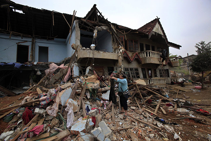 Myanmar earthquake: A woman looks for clothes at her damaged house