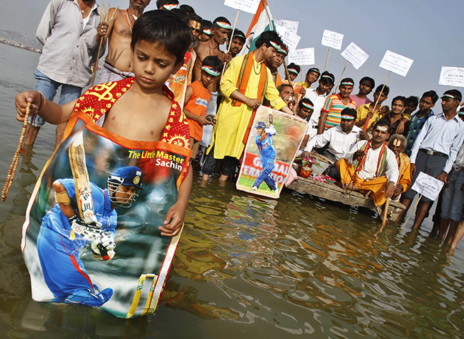 Cricket World Cup Crazy: An Indian boy stands with a poster depicting India's Sachin Tendulkar