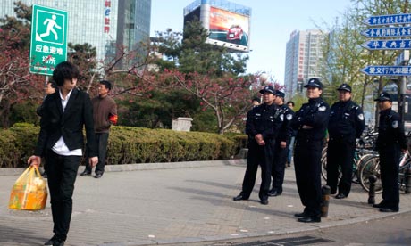 Chinese police officers watch the area where Shouwang church worshippers had planned to gather