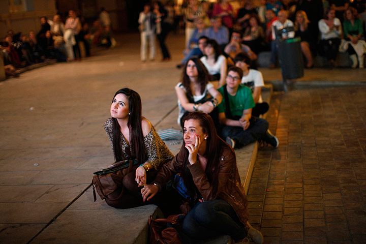 24 hours in pictures: People watch on a screen during a speech in Malaga