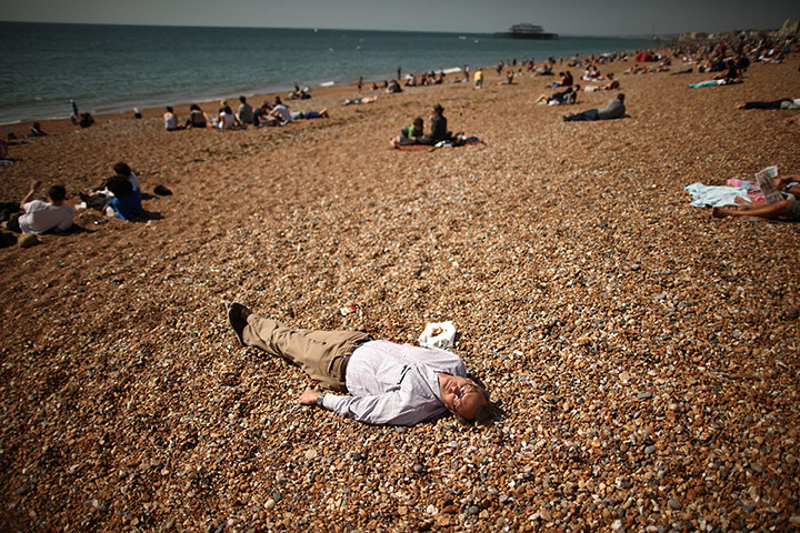24 hours in pictures: A man enjoys a lie down in the sunshine on the beach, Brighton, UK