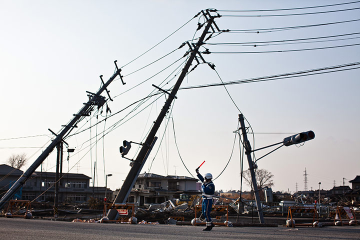 24 hours: Ishinomaki, Japan: A police officer stops cars as he controls the traffic