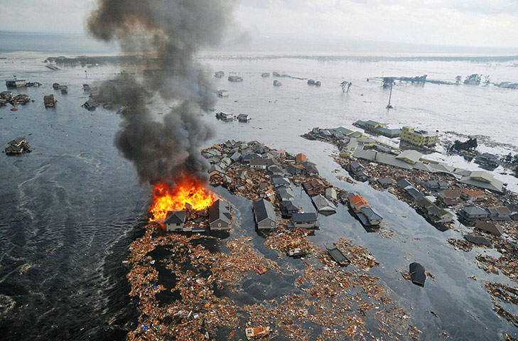 Japan disaster 1 month on: Houses are swept by water following a tsunami and earthquake in Natori City