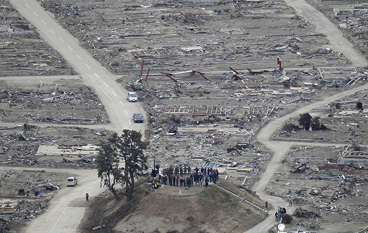 Japan disaster 1 month on: Monks and rescue workers observe a minute of silence in Natori