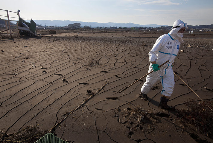 Fukushima disaster: 7 April: A Japanese policeman searches for victims in Minami Soma